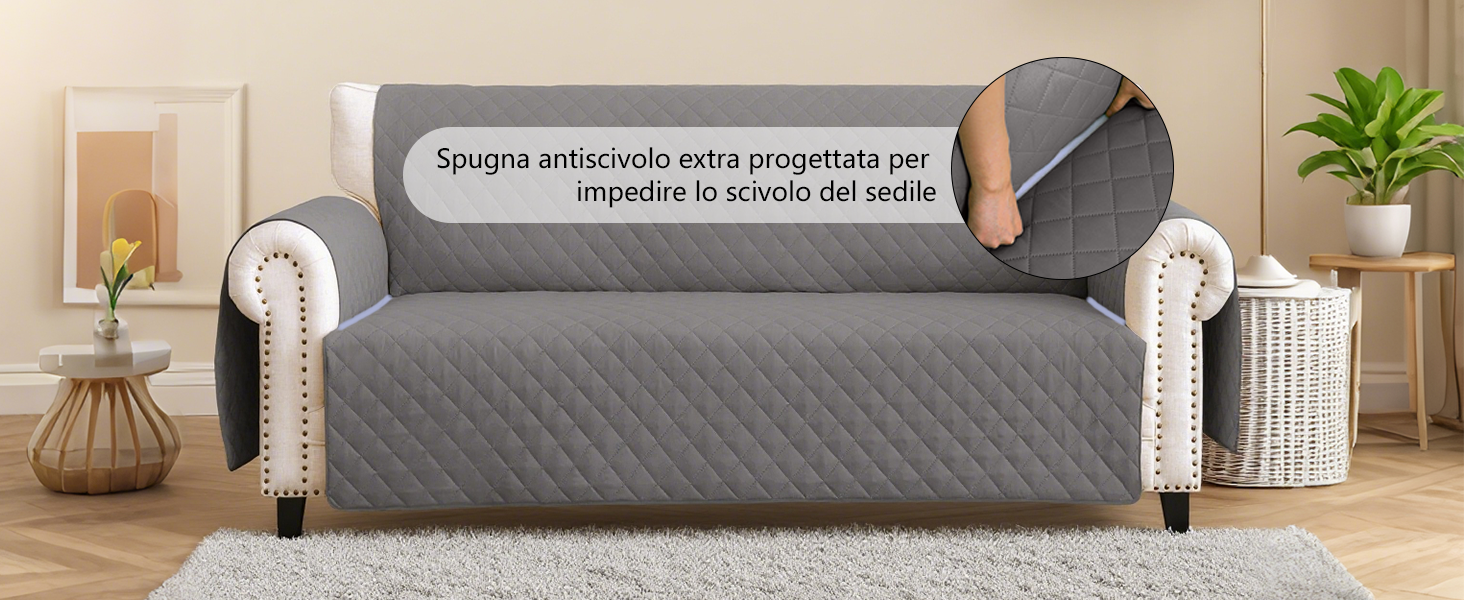 Copridivano trapuntato grigio con cuciture decorative mostrate su un divano in stile tradizionale. Tessuto intrecciato bianco visibile sui braccioli.