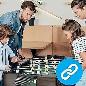 Una partita di biliardino da tavolo che si gioca in un ambiente domestico con scatole mobili di cartone visibili