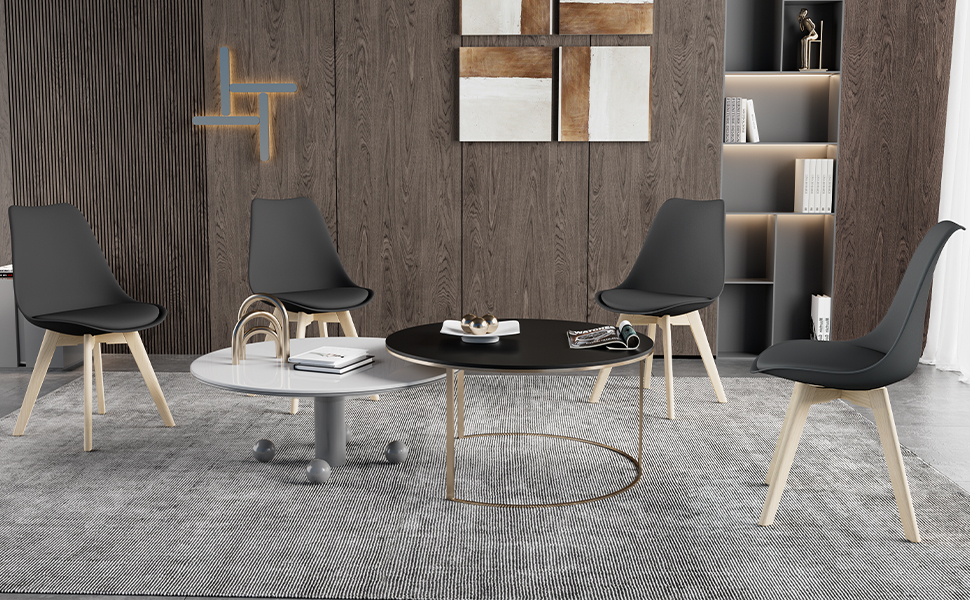 Moderna area salotto per ufficio con quattro sedie nere, gambe in legno, tavolini da caffè rotondi e pareti rivestite in legno con scaffali integrati. Tappeto a motivi grigi