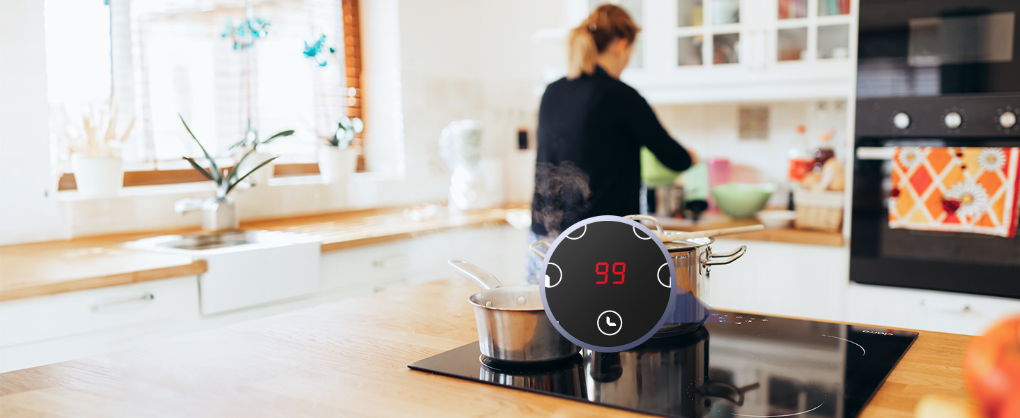 Bilancia da cucina digitale con display circolare su piano di lavoro in legno. Mostra le letture di temperatura e peso. Persona sullo sfondo che usa la cucina