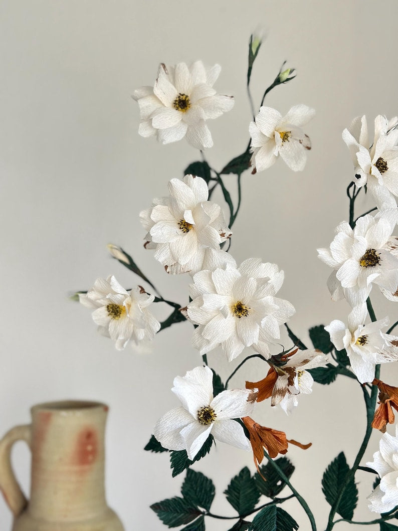 Rosa blanca realista hecha de papel crepé en una maceta de terracota.