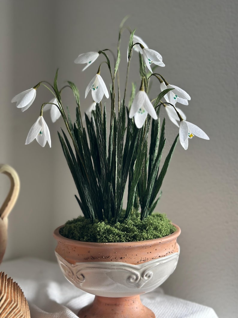 Arreglo floral de flores realistas de papel crepé en una maceta de terracota.