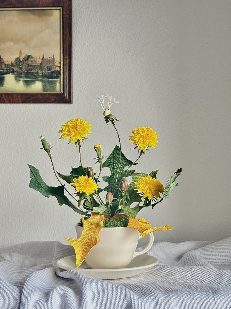 Flores de diente de león amarillas realistas hechas de papel crepé en una taza de té.