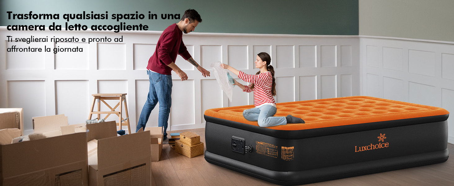 Materasso gonfiabile arancione e nero in una stanza con scatole mobili. Due persone che interagiscono