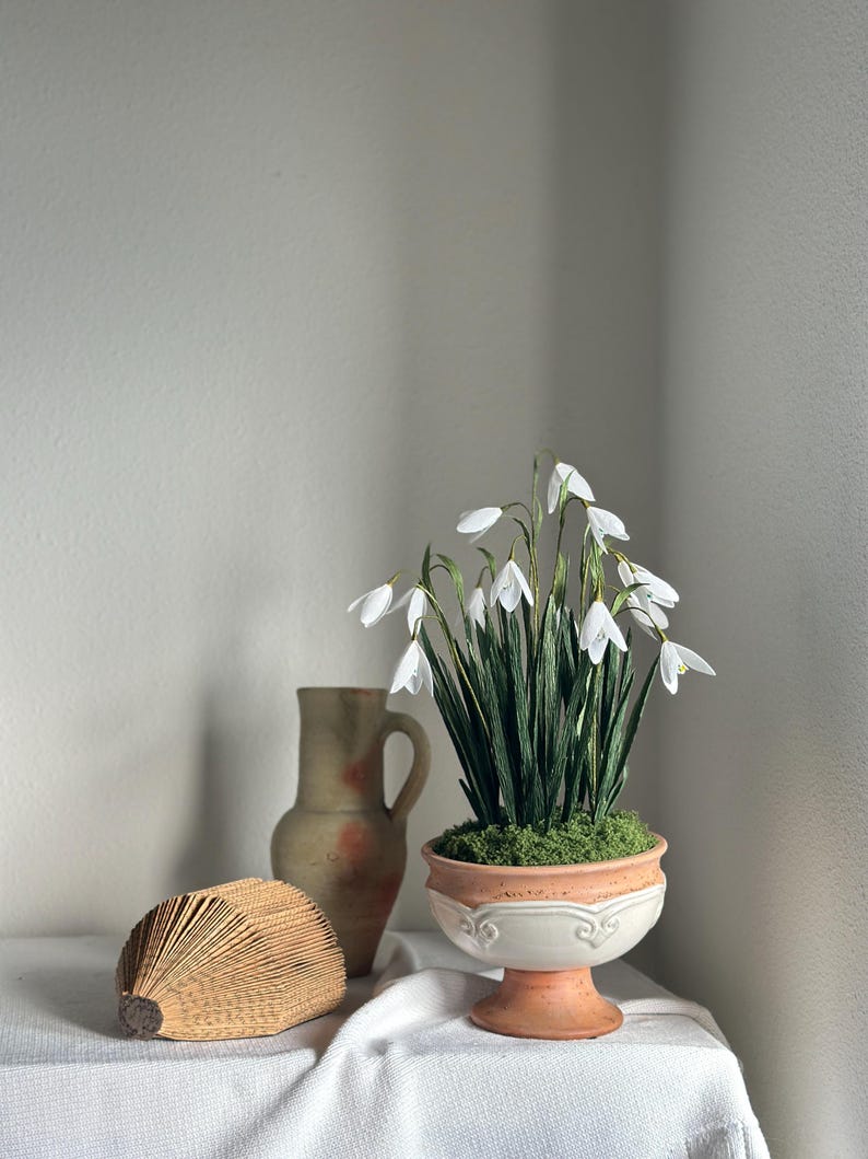 Arreglo floral de flores realistas de papel crepé en una maceta de terracota.