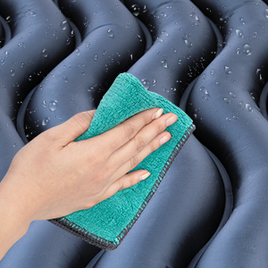 una mano che tiene un asciugamano blu sopra un cuscino blu