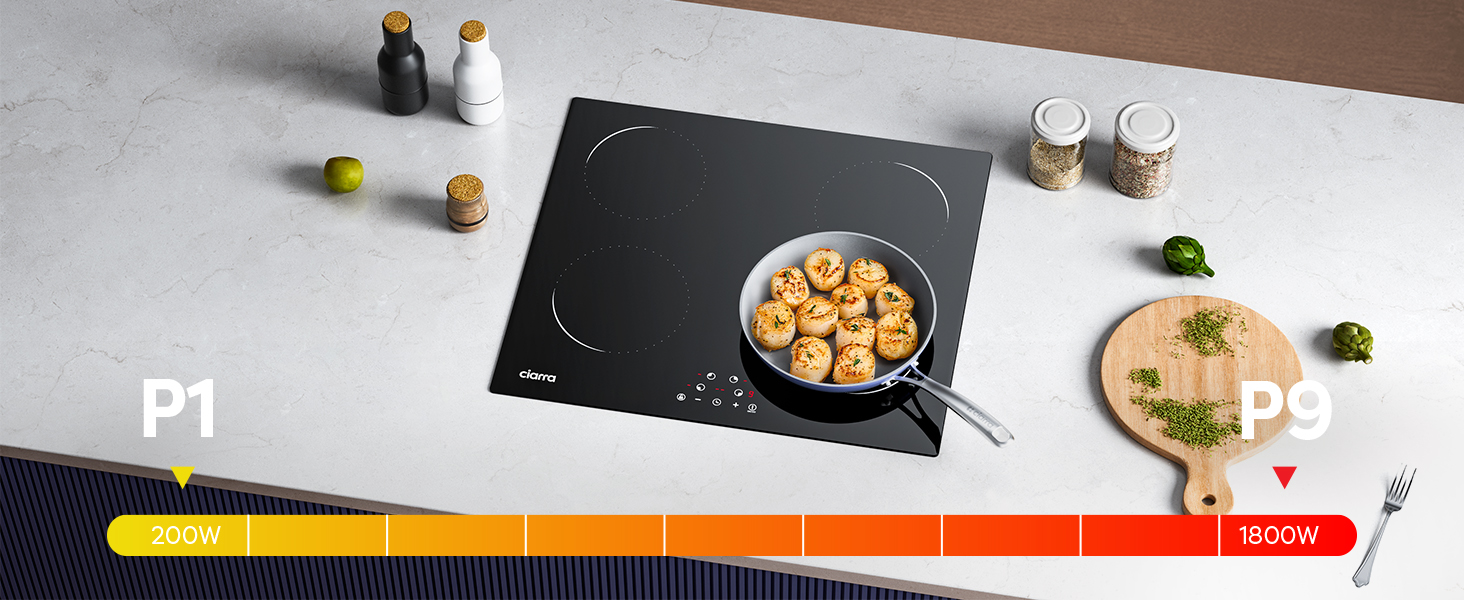 Piano cottura a induzione nero su superficie grigia. Padella con cibo sul piano cottura. Ingredienti e utensili vari che circondano