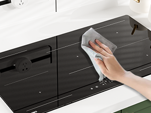 Pulire a mano un piano cottura nero o una superficie di cottura con un panno bianco,