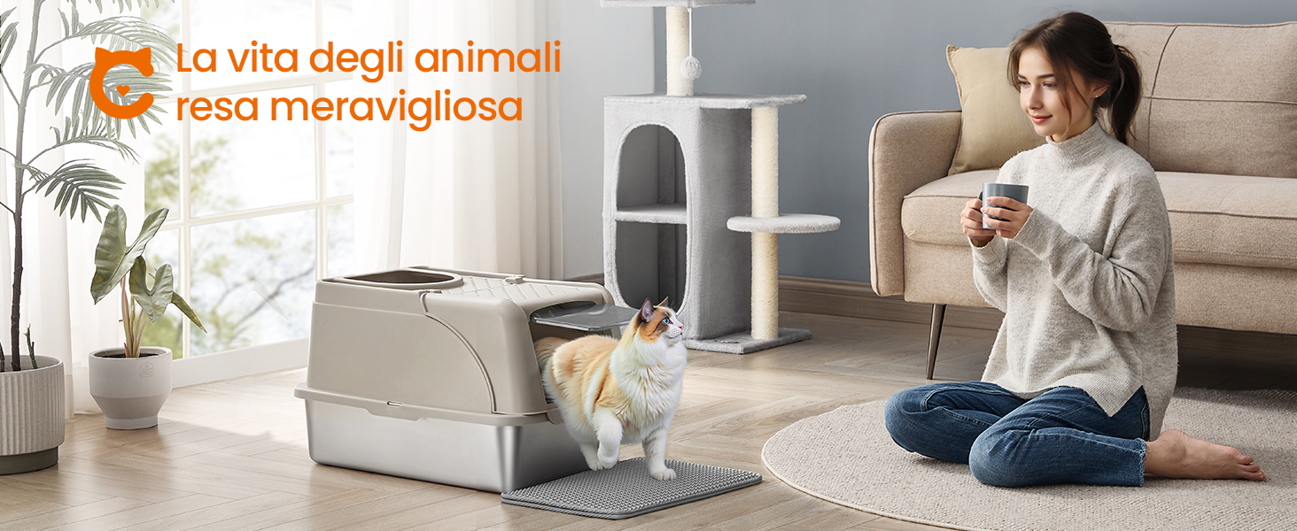 Scena interna con gatto che utilizza lettiera automatica. La donna si siede nelle vicinanze con in mano una tazza. Tiragraffi per gatti e piante visibili. Il testo in italiano si sovrappone all'immagine