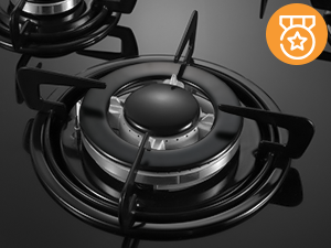 Fornello a gas moderno mostrato in finitura nera con design circolare e griglie metalliche, fotografato dall'alto con un'icona arancione