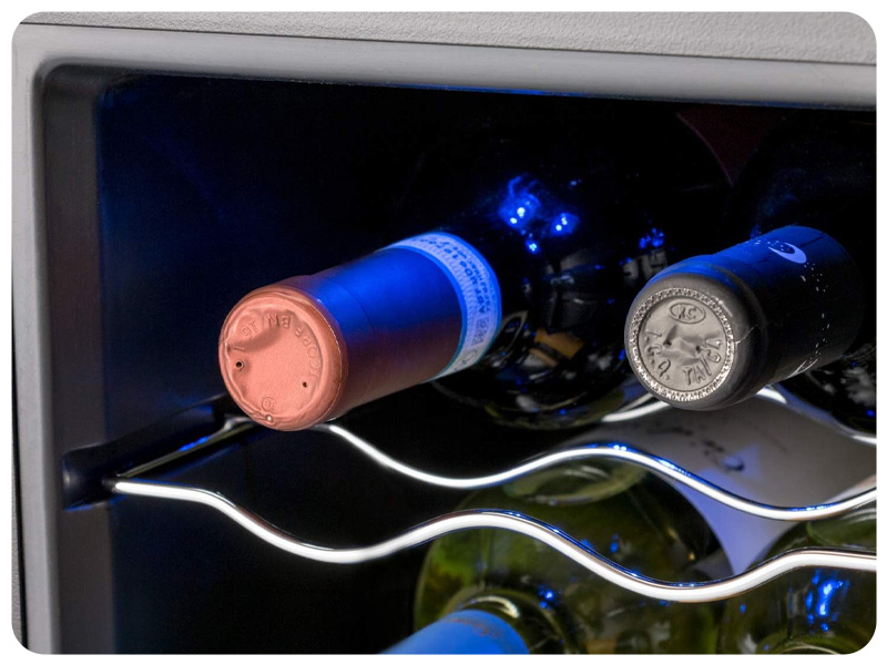 Frigorifero per vino interno con illuminazione a LED blu. Due bottiglie visibili su una griglia metallica ondulata, che mostra lo stoccaggio a temperatura controllata.