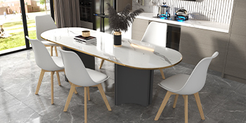 Tavolo da pranzo ovale moderno con piano bianco e base nera, circondato da quattro sedie bianche modellate con gambe in legno. Il tavolo include un centrotavola decorativo a base di piante