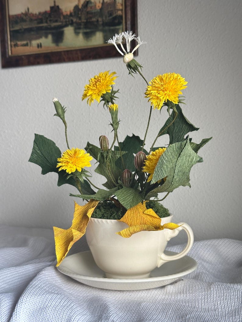 Flores de diente de león amarillas realistas hechas de papel crepé en una taza de té.