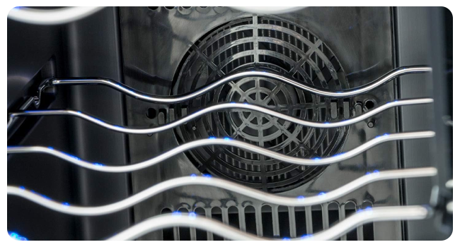 Primo piano di aste o fili metallici curvi davanti a una griglia o una presa d'aria circolare, che mostra un motivo astratto di