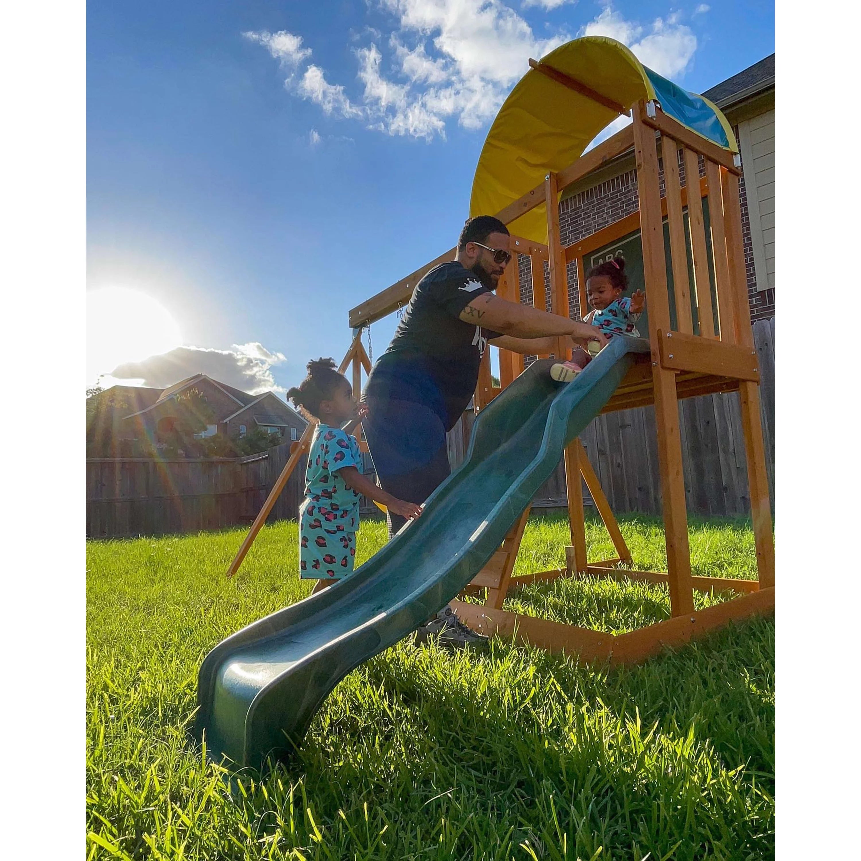 El conjunto de juegos al aire libre KidKraft Ainsley con resbaladilla y pared para escalar