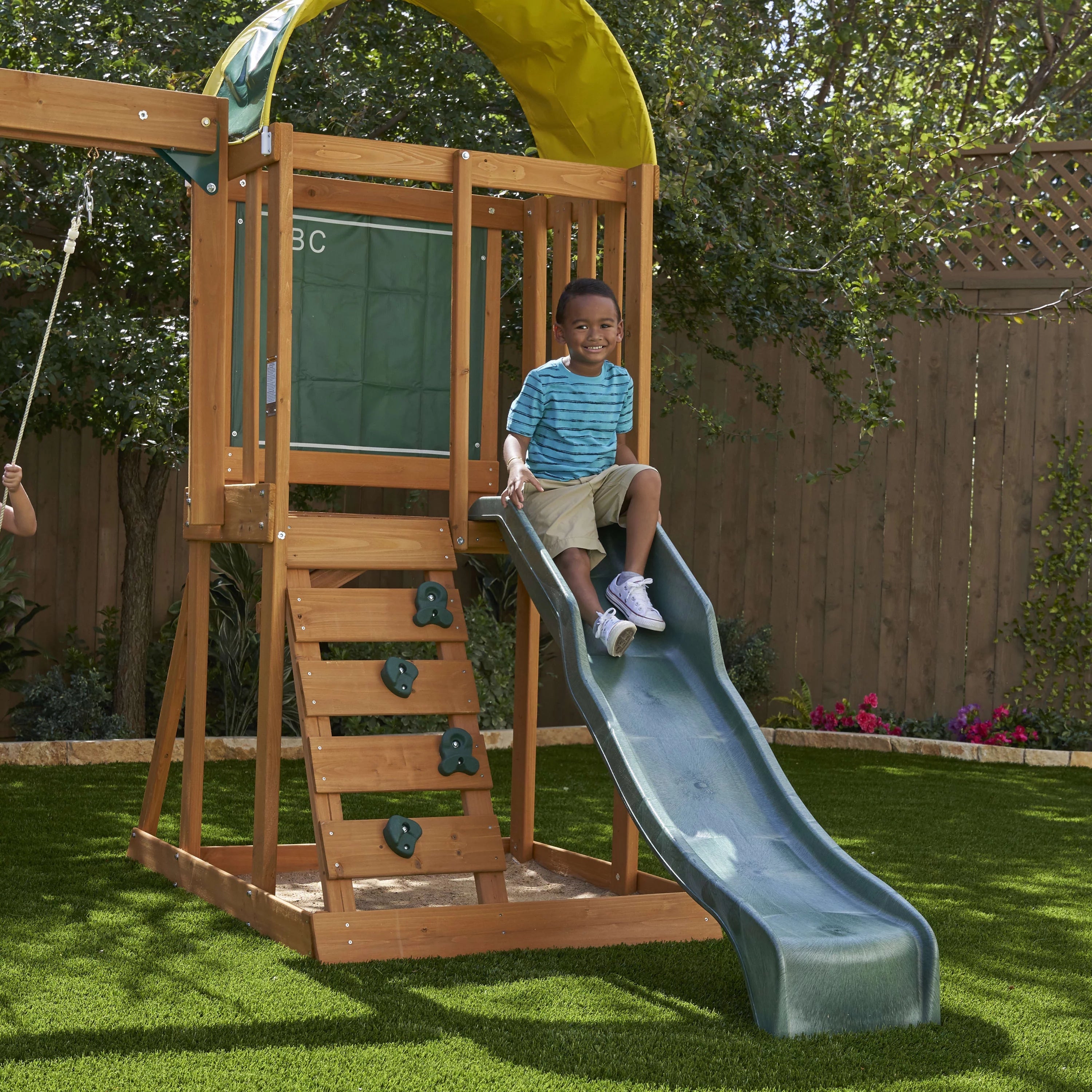 El conjunto de juegos al aire libre KidKraft Ainsley con resbaladilla y pared para escalar