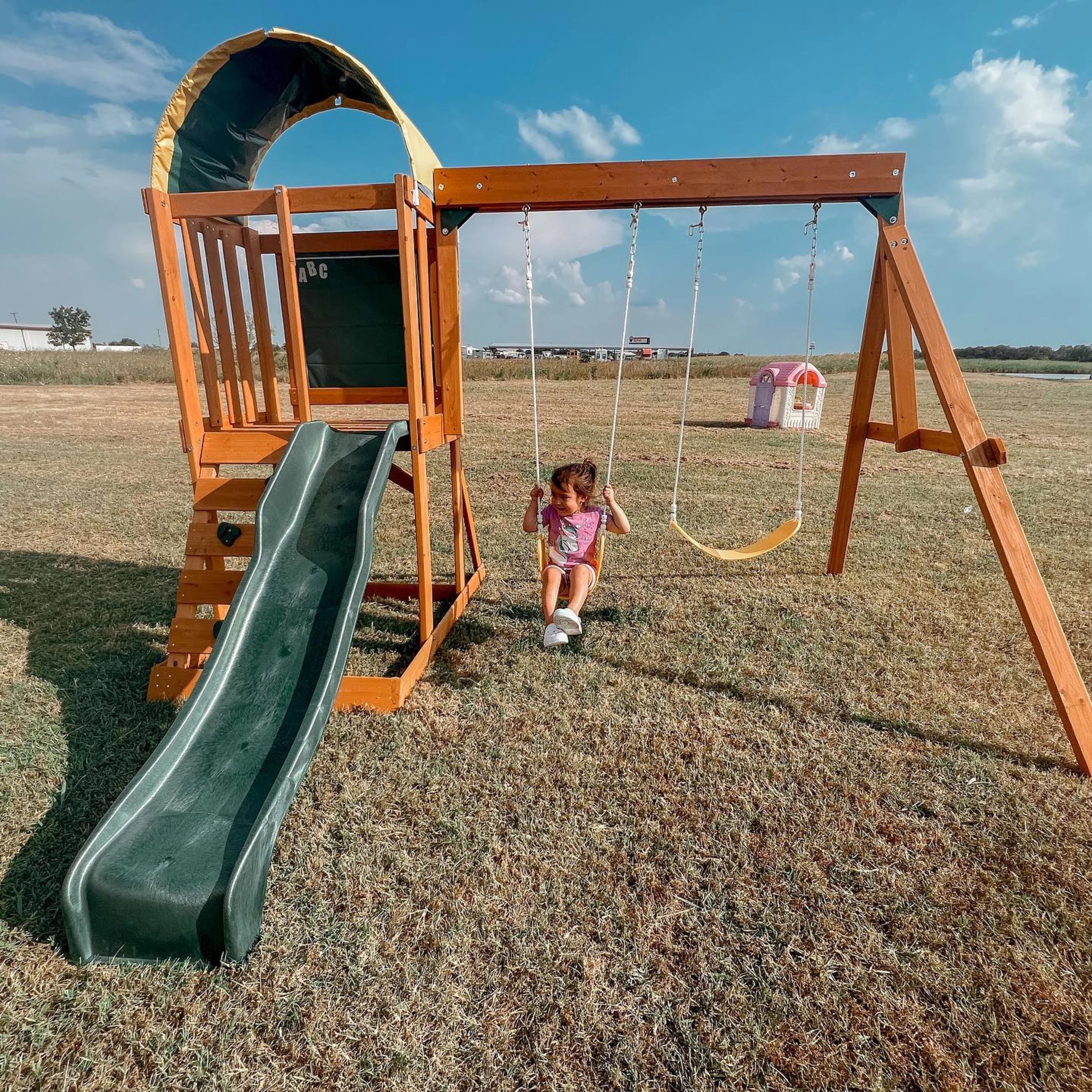 El conjunto de juegos al aire libre KidKraft Ainsley con resbaladilla y pared para escalar